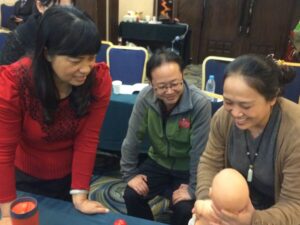 Three woman with a baby doll